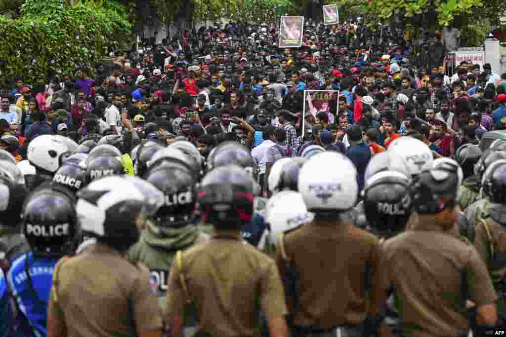 Policemen stand guard as protesters take part in an anti-government demonstration by the university students demanding the release of their leaders, in Colombo, Sri Lanka, Oct. 18, 2022.