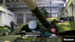 Оновлений танк радянського дизайну T-72 на ремонтному заводі у Києві в лютому 2021 р. У боях з російським вторгненням Україна здобула чимало трофейних російських танків, але в активних бойових діях втрачає десятки танків на місяць.