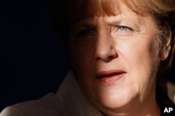 FILE - German Chancellor Angela Merkel is pictured with light and shadow at the Meseberg palace near Berlin, Germany.