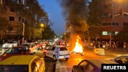 Sebuah sepeda motor polisi terbakar saat protes atas kematian Mahsa Amini, seorang peremouan yang meninggal setelah ditangkap oleh "polisi moral" republik Islam itu, di Teheran, Iran 19 September 2022. (Foto: via Reuters)