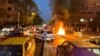 FILE - A police motorcycle burns during a protest over the death of Mahsa Amini, a woman who died after being arrested by the Islamic republic's "morality police", in Tehran, Iran Sept. 19, 2022.