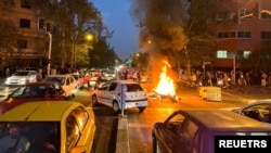 FILE - A police motorcycle burns during a protest over the death of Mahsa Amini, a woman who died after being arrested by the Islamic republic's "morality police", in Tehran, Iran Sept. 19, 2022.