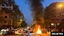 FILE - A police motorcycle burns during a protest over the death of Mahsa Amini, a woman who died after being arrested by the Islamic republic's "morality police," in Tehran, Iran, Sept. 19, 2022.