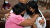 FILE - Catholic priest Flaviano "Flavie" Villanueva comforts relatives as they receive the urn containing the remains of victims of alleged extrajudicial killings at a church in Quezon city, Philippines, Wednesday, Sept. 28, 2022.