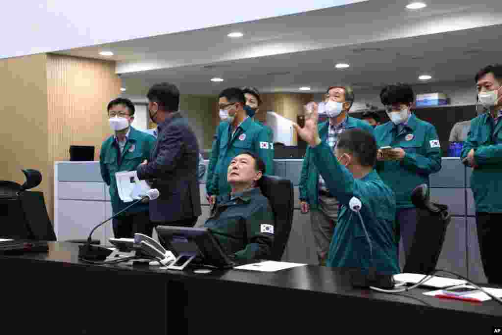 In this photo provided by the South Korean Presidential Office, President Yoon Suk Yeol, center, attends an emergency meeting at the presidential office in South Korea, Oct. 30, 2022. 