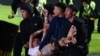 In this Oct. 1, 2022, picture, a group of people carry a man after a football match between Arema FC and Persebaya Surabaya at Kanjuruhan stadium in Malang, East Java.