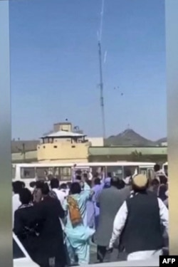 This grab taken from a UGC video posted online Sept. 30, 2022, shows Iranians hurling stones at a police station in the southeastern city of Zahedan.