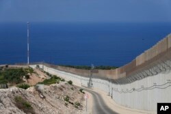FILE - The wall on the Israeli border with Lebanon, is seen at right, with the Mediterranean Sea in the distance, in Ras Hanikra, Israel, Oct. 14, 2022.
