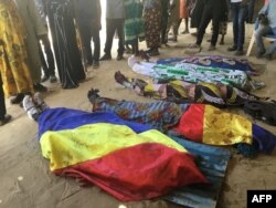 Bodies covered by Chadian flags are lined up on the ground during a protest in N'Djamena, Chad, Oct. 20, 2022.