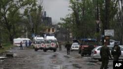 FILE - Red Cross vehicles are seen in Mariupol, in Ukraine's now Russia-annexed Donetsk region, May 18, 2022.