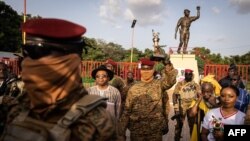 Captain Ibrahim Traore, Burkina Faso's new president, poses with a torch during the ceremony for the 35th anniversary of the assassination of revolutionary President Thomas Sankara, in Ouagadougou, Oct. 15, 2022.
