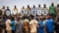 Mourners hold photos of some of the 27 soldiers killed as they escorted 207 vehicles in a convoy during their funeral at the General Sangoule Lamizana military camp in Ouagadougou, Burkina Faso, Oct. 8, 2022.
