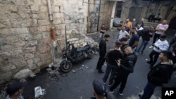 Palestinians gather around the motorcycle that Palestinian militant group Den of Lions says was planted with an explosive device, killing one of its top fighters as he walked past, in the Old City of Nablus in the West Bank, Oct. 23, 2022.