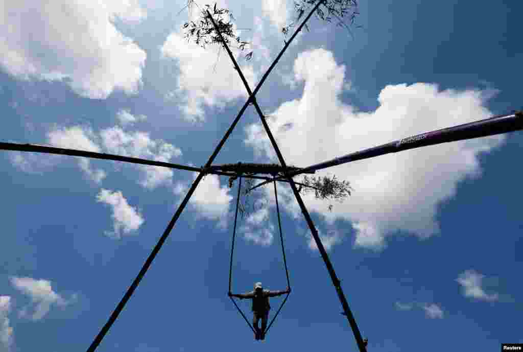 A boy plays on a swing made from bamboo during Dashain, the country’s biggest religious Hindu festival, in Kathmandu, Nepal, Sept. 28, 2022. 