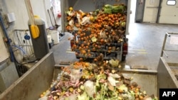 FILE - A truck offloads bio-waste of fruits and vegetables, in Stains, France, Nov. 19, 2021.