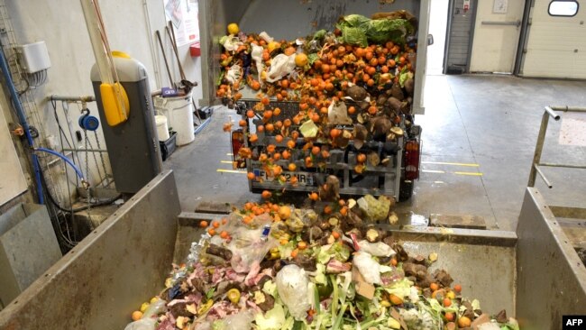 FILE - A truck offloads bio-waste of fruits and vegetables, in Stains, France, Nov. 19, 2021.