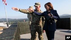U.S. Vice President Kamala Harris, right, uses binoculars at the military observation post as she visits the demilitarized zone (DMZ) separating the two Koreas, in Panmunjom, South Korea Thursday, Sept. 29, 2022.