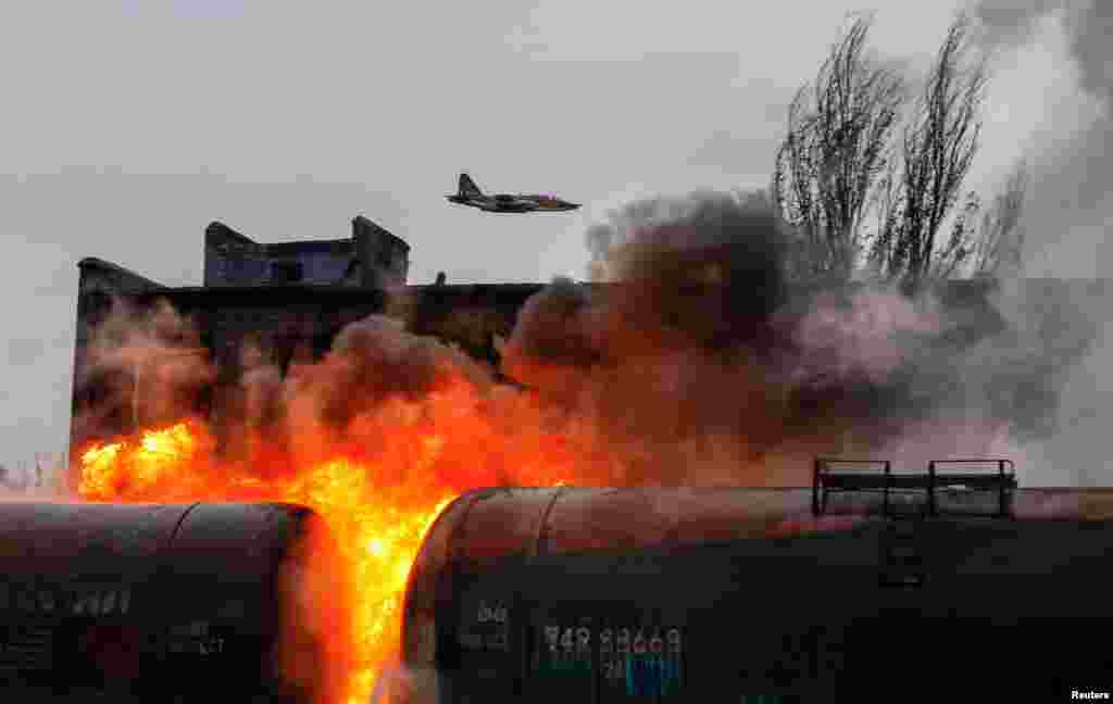 A Russian fighter jet flies above a railway junction on fire following recent shelling in the town of Shakhtarsk (Shakhtyorsk) near Donetsk, Russian-controlled Ukraine.