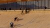 Migrantes que buscan asilo, en su mayoría de Venezuela, salen del río Bravo después de cruzarlo para entregarse a los agentes de la Patrulla Fronteriza de EEUU y pedir asilo en El Paso, Texas; visto desde Ciudad Juárez, México, el 6 de octubre de 2022 .