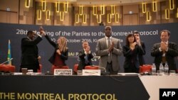 FILE - Members of the organizing committee celebrate the adoption of the Kigali Amendment to the Montreal Protocol, Oct. 15, 2016 in Kigali, Rwanda. With the amendment, nations agreed to phase out a category of dangerous widely-used greenhouse gases.