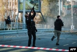 A police officer fires at a drone following attacks in Kyiv, Ukraine, Oct. 17, 2022.