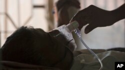  A relative adjusts the oxygen mask of a tuberculosis patient at a hospital in Hyderabad, India, March 24, 2018. Tuberculosis cases rose for the first time in years, says a report issued Thursday, Oct. 27, 2022 by the World Health Organization. (AP Photo/Mahesh Kumar A., File)