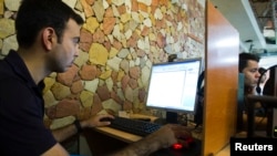 FILE - A customer uses a computer at an internet cafe in Tehran, May 9, 2011. An online coalition on Oct. 20, 2022, blasted Iran’s restrictions on internet access during nationwide protests over the death of Mahsa Amini the previous month. 
