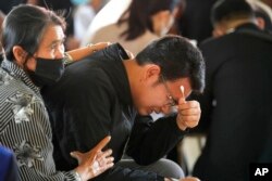 Seksan Sriraj, 28, berduka saat upacara bagi mereka yang tewas dalam serangan di kota pedesaan Uthai Sawan, timur laut Thailand, 7 Oktober 2022. (Foto: AP)