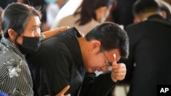 Seksan Sriraj, 28, grieves during a ceremony for those killed in the attack on the Young Children's Development Center in the rural town of Uthai Sawan, northeastern Thailand, Oct. 7, 2022.