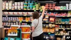 FILE - A customer looks at refrigerated items at a Grocery Outlet store in Pleasanton, Calif., Sept. 15, 2022.