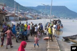 People stranded due to floods following several days of downpours In Kogi Nigeria, Oct. 6, 2022. Further south, in Anambra State, 85 people were on a boat when it capsized, Oct. 7, 2022.