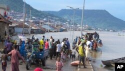 FILE - People stranded due to floods following several days of downpours In Kogi Nigeria, Oct. 6, 2022. Further south, in Anambra State, 85 people were on a boat when it capsized, Oct. 7, 2022. 