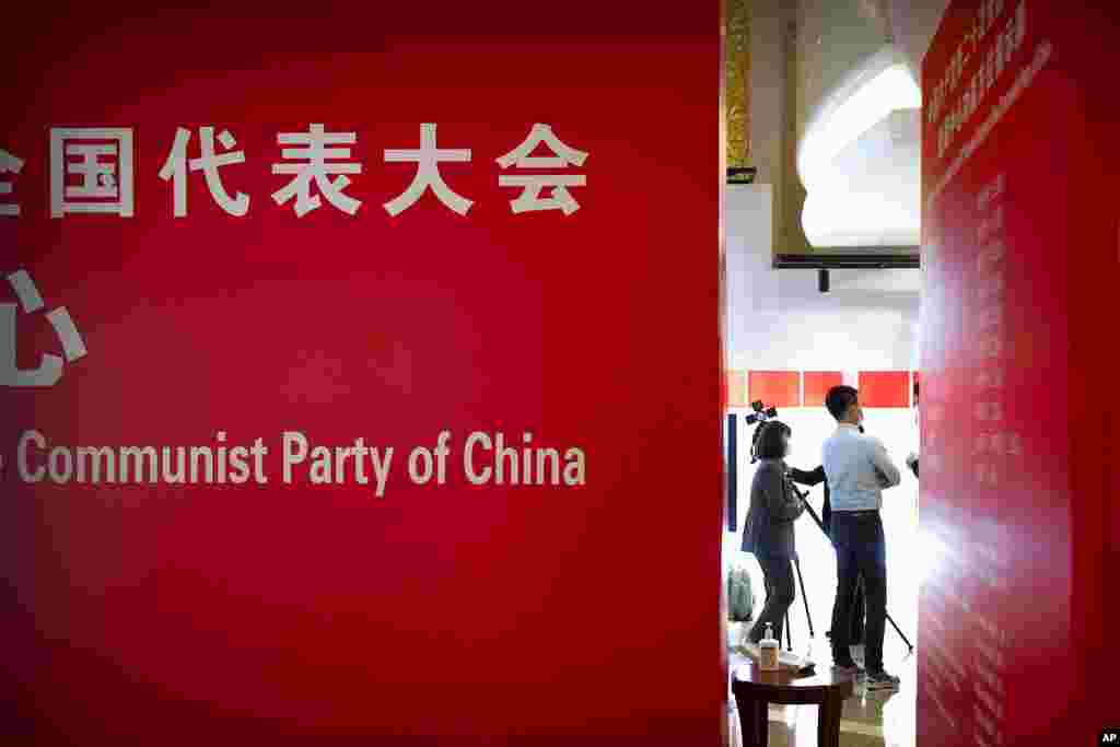 People stand in a hotel for reporters covering the 20th National Congress of China&#39;s ruling Communist Party in Beijing. Chinese President Xi Jinping is widely expected to be given a third five-year term in office during the congress, which begins Sunday.