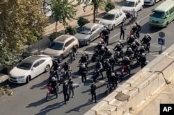 In this frame grab from video taken by an individual not employed by AP and obtained outside Iran shows Iranian police arrive to disperse a protest to mark 40 days since the death in custody of Mahsa Amini, in Tehran, Oct. 26, 2022.