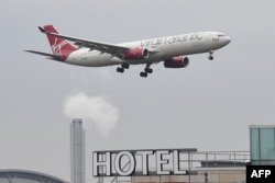Pesawat penumpang Virgin Atlantic Airbus A330 terlihat di atas sebuah hotel saat akan mendarat di Bandara Heathrow London, 14 Februari 2021.(Daniel SLIM / AFP)