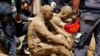 Petugas pemadam kebakaran mendatangi relawan yang berbalut lumpur dalam upaya evakuasi korban bencana tanah longsor di Las Tejerias, negara bagian Aragua, Venezuela, pada 10 Oktober 2022. (Foto: Reuters/Leonardo Fernandez Viloria)
