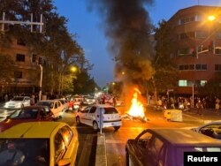 FILE - A police motorcycle burns during a protest over the death of Mahsa Amini, a woman who had been arrested by the Islamic republic's "morality police," in Tehran, Iran, Sept. 19, 2022.