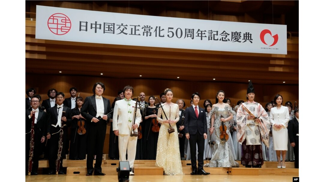 Sutradara Keita Matsui, barisan depan, dari kiri; pemain erhu Zhang Bin dan Zhang Hina, skater Yuzuru Hanyu, pemain biola Ikuko Kawai, pemain musik tradisional Jepang "gagaku" Hidfeki Togi dan pembawa acara Yukari Nishio berpose untuk foto bersama pemain lain sebelum acara perayaan 50 tahun normalisasi hubungan Jepang dan China, di Tokyo, Kamis, 29 September 2022. (AP/Hiro Komae)