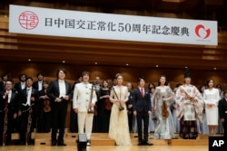 Sutradara Keita Matsui, barisan depan, dari kiri; pemain erhu Zhang Bin dan Zhang Hina, skater Yuzuru Hanyu, pemain biola Ikuko Kawai, pemain musik tradisional Jepang "gagaku" Hidfeki Togi dan pembawa acara Yukari Nishio berpose untuk foto bersama pemain lain sebelum acara perayaan 50 tahun normalisasi hubungan Jepang dan China, di Tokyo, Kamis, 29 September 2022. (AP/Hiro Komae)