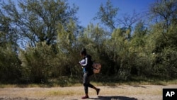 Una ciudadana cubana camina por una carretera después de cruzar la frontera entre México y Texas en el Río Grande, el 23 de septiembre de 2021, en Del Rio, Texas.