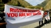 FILE - Activists hold an anti-Russian banner during an action organized by political party Droa near the border crossing at Verkhny Lars between Georgia and Russia in Georgia, Sept. 28, 2022. Some Georgians hace voiced concerns about the exodus of Russians into their country.