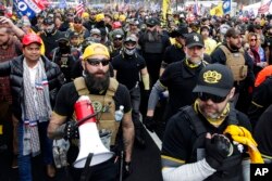 FILE - Proud Boys member Jeremy Bertino, second from left, joins other supporters of President Donald Trump at a rally at Freedom Plaza, in Washington, Dec. 12, 2020.