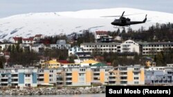 A helicopter patrols off Tromsoe, Norway, June 2, 2012. REUTERS/Saul Loeb/Pool/File Photo