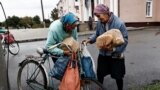 Raisa, 67, and her relative receive humanitarian aid in the recently liberated town of Izium, in Kharkiv region, Ukraine.