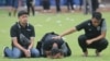 Arema FC players and officials react as they visit Kanjuruhan Stadium, after a riot and stampede following a soccer match between Arema vs Persebaya in Malang, East Java province, Indonesia. (Antara Foto. Antara Foto/Prasetia Fauzani/via Reuters)