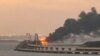 A fire is seen on the Kerch bridge at sunrise in the Kerch Strait, near Russia-annexed Crimea, Oct. 8, 2022.