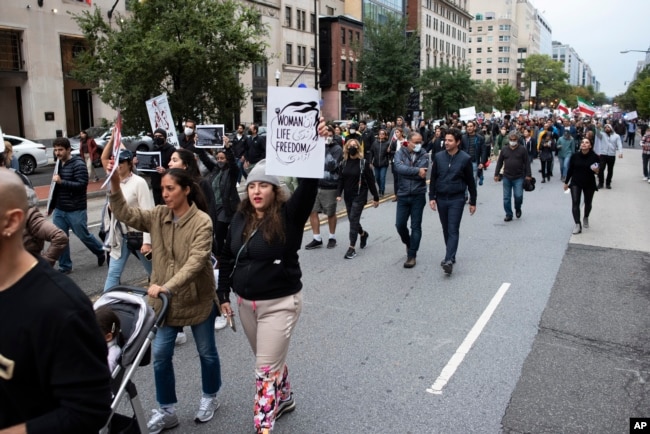 Protestors march through Washington, D.C., Saturday Oct. 1, 2022, during a rally calling for regime change in Iran following the death of Mahsa Amini, a young woman who died after being arrested in Tehran by Iran's notorious "morality police."