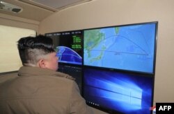 This undated picture released from North Korea's official Korean Central News Agency (KCNA) on Oct. 10, 2022, shows North Korea's leader Kim Jong Un looking at a monitor with the trajectory of a missile that fell over the Japanese archipelago on October 4 into the Pacific Ocean, at an undisclosed location.