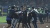 Sejumlah suporter berupaya mengevakuasi seorang pria yang terkena tembakan gas air mata setelah kisruh meletus selepas pertandingan antara Arema melawan Persebaya di stadion Kanjuruhan, Malang, pada 1 Oktober 2022. (Foto: Antara Foto/Ari Bowo Sucipto/via Reuters)