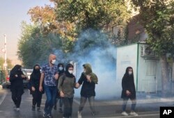 FILE - In this Oct. 1, 2022, photo taken by an individual not employed by the Associated Press and obtained by the AP outside Iran, tear gas is fired by security to disperse protestors in front of the Tehran University, Iran.